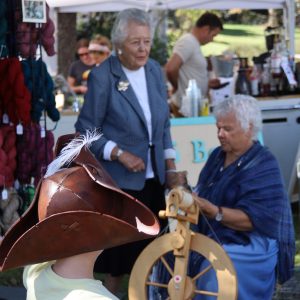Photo of Susan Withnell spinning at the wheel at the Waterford Fair