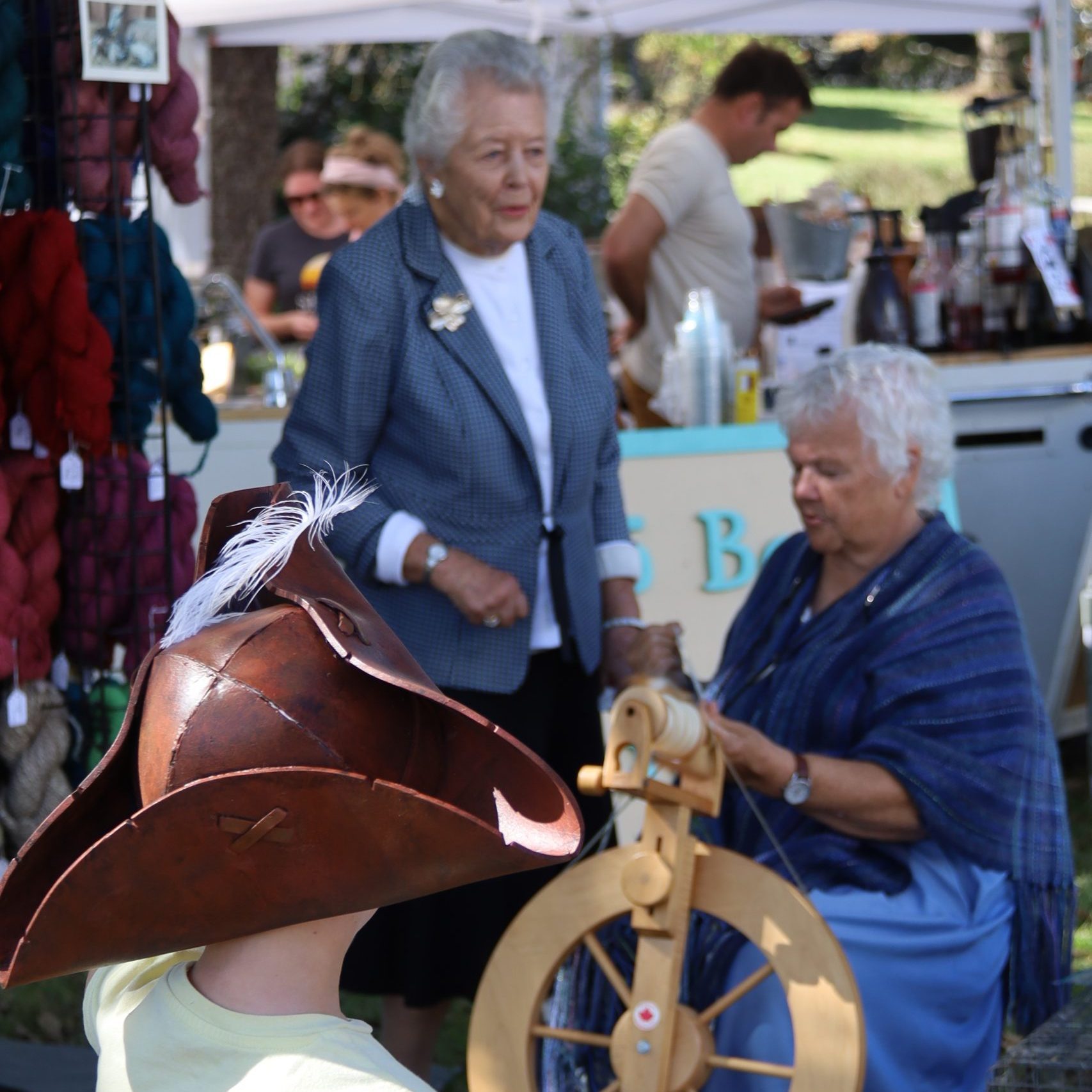 Photo of Susan Withnell spinning at the wheel at the Waterford Fair